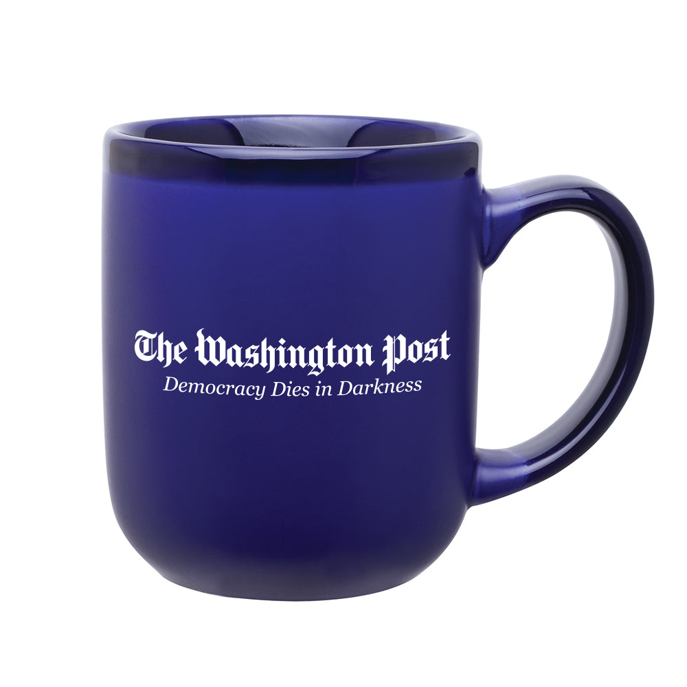 Royal blue mug with darker blue rim and handle. In the middle of the hug is The Washington Post and Demoracy Dies in Darkness in white text.
